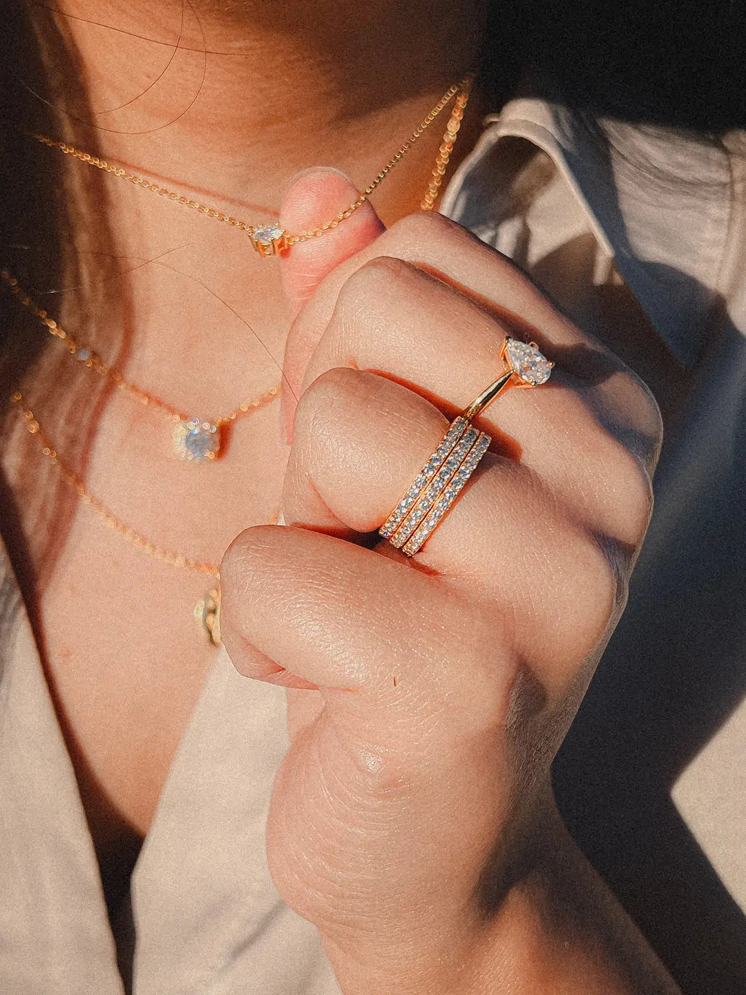 Dame med exo diamantsmykker på seg, en diamant forlovelsesring, en giftering, to diamantkjeder og et anheng, hæ